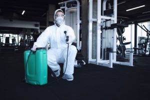 Foto de un empleados limpiando y desinfectando un gimnasio