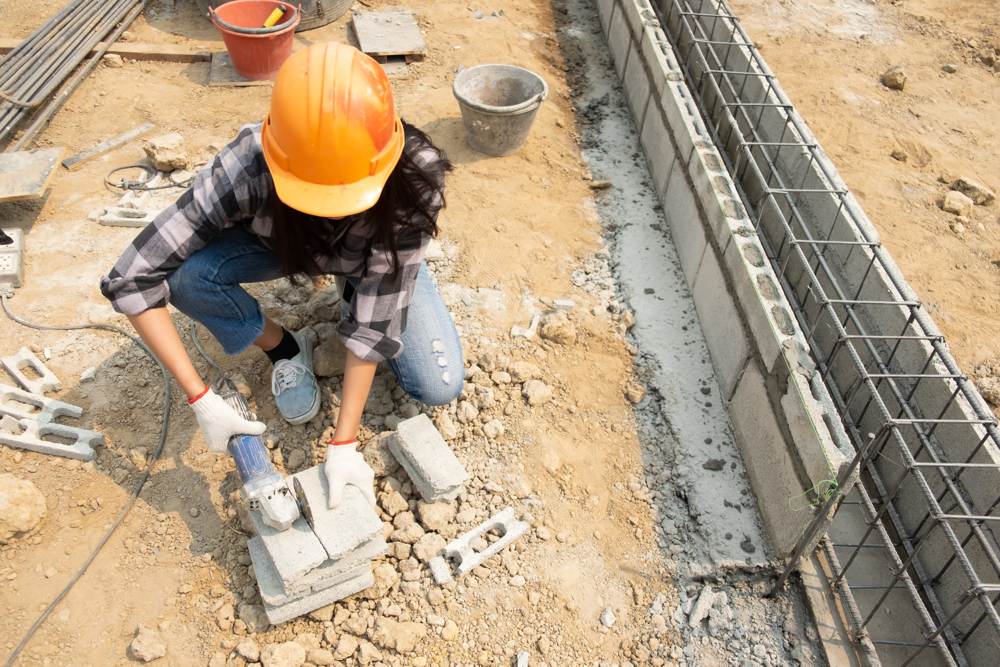 Una trabajadora de Rojeque cortando ladrillos para la construcción de una vivienda